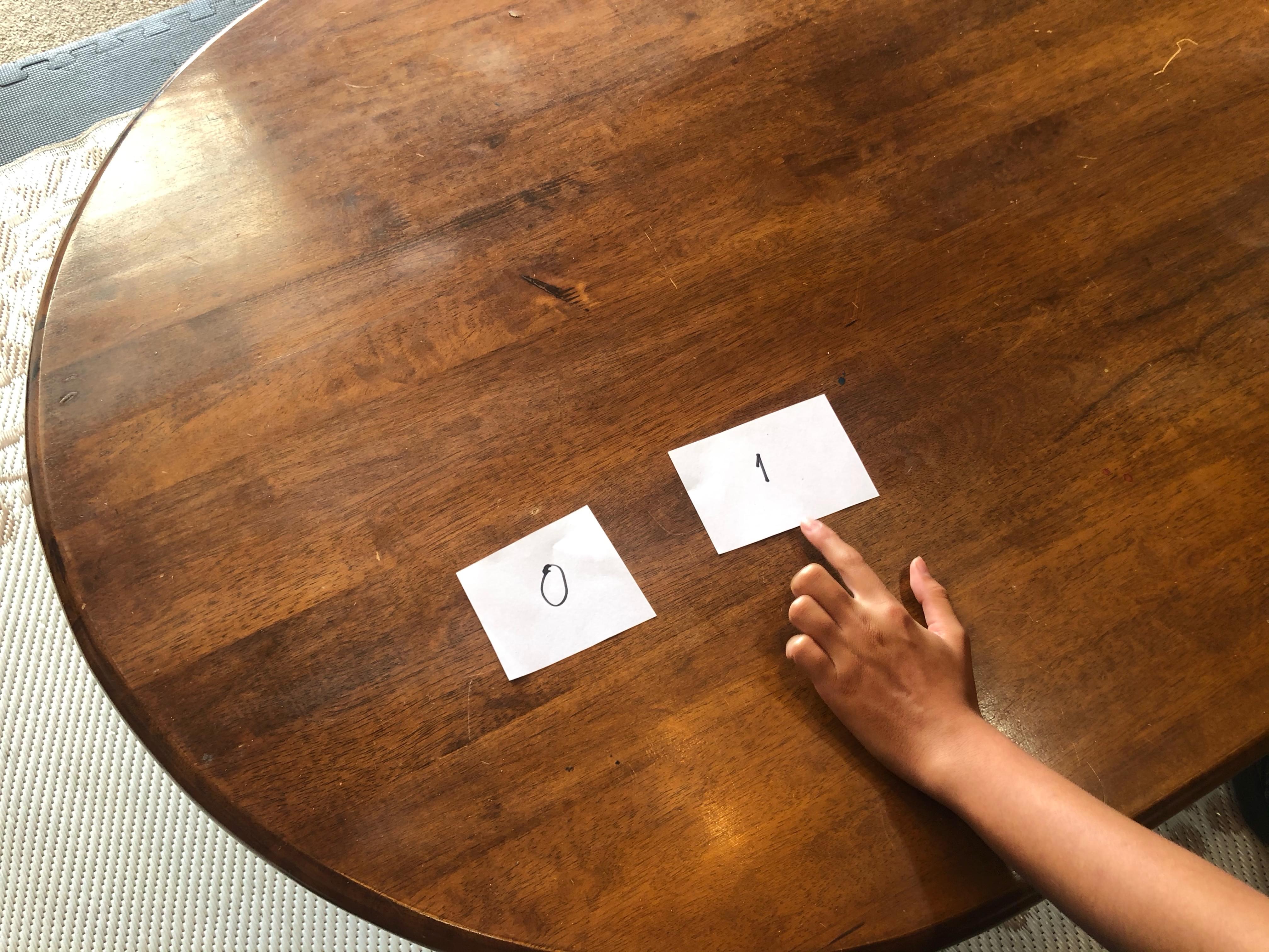 Child pointing to the card with the number 1 on it.
