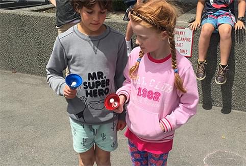 Two students compare the pitch of their bells.